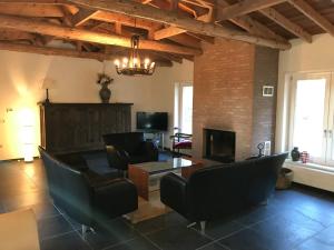 a living room with black chairs and a fireplace at Het Atelier, ruime vrijstaande vakantiewoning 200m2 voor maximaal 8 personen in Leende