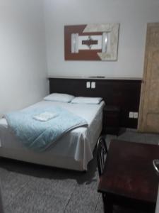 1 dormitorio con 1 cama en una habitación con mesa en Araca Hotel, en Araçatuba