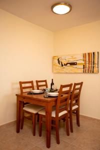einen Esstisch mit Stühlen und ein Gemälde an der Wand in der Unterkunft Vivienda vacacional 525 La Manga in La Manga del Mar Menor