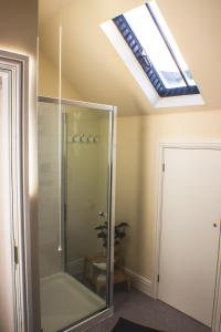 een badkamer met een douche en een dakraam bij Penmaenmawr Bed & Breakfast in Penmaen-mawr