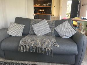 a gray couch with pillows on it in a living room at The Boathouse in Carbis Bay
