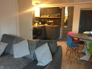 a living room with a couch and a table and a kitchen at The Boathouse in Carbis Bay