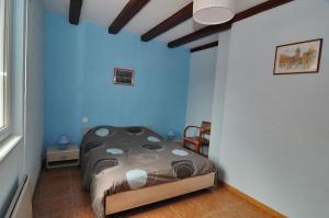 1 dormitorio con 1 cama en una habitación con paredes azules en LA MAISON FLEURIE Gîtes du Florimont, en Ingersheim