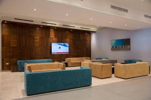 a waiting room with couches and a flat screen tv at Paradise Bay Resort in Mellieħa