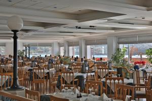 a large banquet hall with tables and chairs and windows at Paradise Bay Resort in Mellieħa
