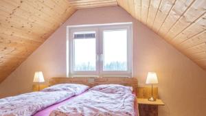 1 Schlafzimmer mit 2 Betten und 2 Fenstern in der Unterkunft Landhaus Seewald in Seewald