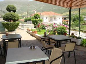 a patio with tables and chairs and flowers at Stalaktites in Ioannina