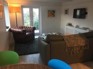 a living room with a couch and a chair at The Boathouse in Carbis Bay