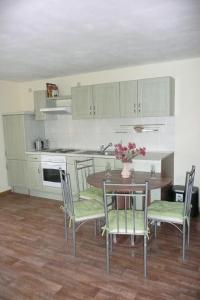 a kitchen with a table and chairs and a kitchen with white cabinets at Ferienwohnung "Zur Wilke" in Stadt Wehlen