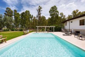 uma piscina com um gazebo ao lado de uma casa em Villa Pizzi by BarbarHouse em San Donaci