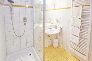 a bathroom with a shower and a sink and a toilet at Berghotel Sonnenklause in Sonthofen