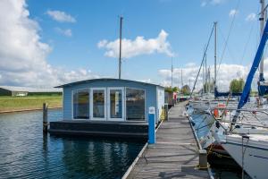 a small boat docked at a dock in the water at Waterlodge in Wilhelminadorp
