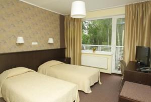 Pühajärve Spa & Holiday Resort في أوتيبا: غرفة فندقية بسريرين وبلكونة
