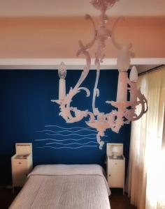 Caronia MarinaにあるDimora Damareの青い壁のベッドルーム(シャンデリア付)