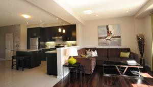 uma sala de estar e cozinha com um sofá e uma mesa em Boardwalk Homes Vacation & Bridal Guest Houses em Kitchener