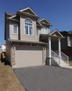 a large house with a garage door in front of it at Boardwalk Homes Vacation & Bridal Guest Houses in Kitchener