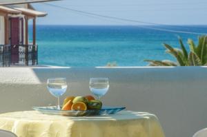 
a table topped with a glass of wine and a plate of food at Sunday Studios in Agia Anna Naxos
