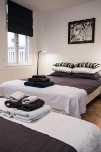 two beds with towels on them in a room at Kuwadro Guesthouse Centrum in Amsterdam