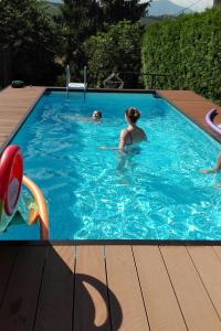dwie osoby pływają w basenie w obiekcie Wirtshaus Meißl w mieście Puch bei Weiz