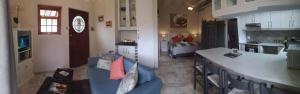 cocina y sala de estar con sofá azul en RAFTERS COTTAGE, en Plumstead