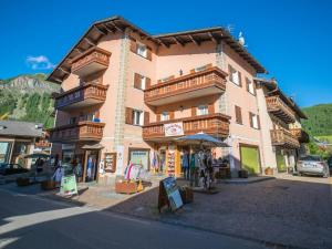 a large building with wooden balconies on a street at Maison Ostaria MyHolidayLivigno in Livigno
