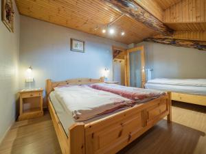 a bedroom with two beds and a wooden ceiling at Apartments & Rooms MyHolidayLivigno in Livigno
