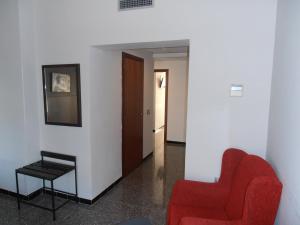 a living room with a red chair and a table at Hotel Marblau Tossa in Tossa de Mar