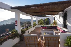 einen Balkon eines Hauses mit einem Tisch und Stühlen in der Unterkunft Holiday Home Tranquilidad in Arenas