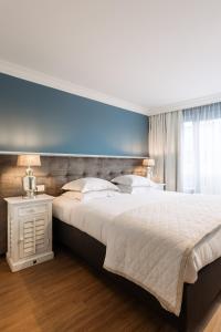 a bedroom with a large bed with a blue wall at Hotel Cocoon in Ostend