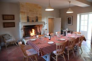a dining room with a table and a fireplace at Belle demeure familiale avec piscine proche St Emilion in Bossugan