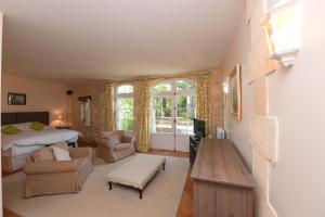 a bedroom with a bed and a living room at Belle demeure familiale avec piscine proche St Emilion in Bossugan +26 photos