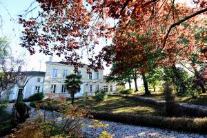 a white house with trees in front of it at Belle demeure familiale avec piscine proche St Emilion in Bossugan