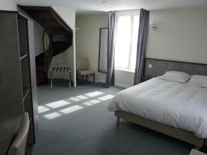 a bedroom with a large bed and a stair case at Beauséjour in Sainte-Suzanne