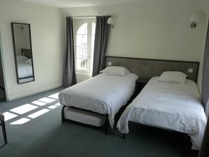 two beds sitting in a room with a mirror at Beauséjour in Sainte-Suzanne