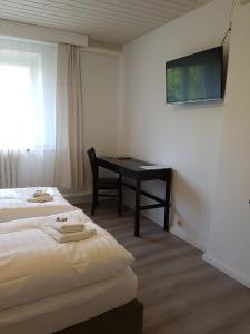 een hotelkamer met twee bedden en een bureau bij Pension New Nomads in Zesch