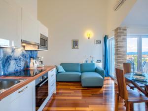 uma cozinha e sala de estar com um sofá azul e uma mesa em Modish Apartment in Murter with Bubble Bath em Murter