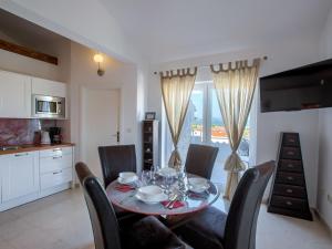 ein Esszimmer mit Tisch und Stühlen und eine Küche in der Unterkunft Apartment in Murter with Pool and Sea Views in Murter