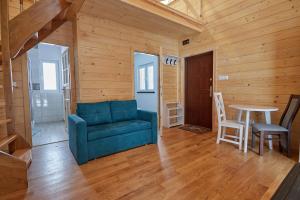 a living room with a blue couch and a table at Sosnowa Osada in Cieszanów