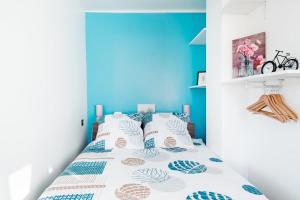 um quarto com uma cama com uma parede azul em LP Anne em Annecy