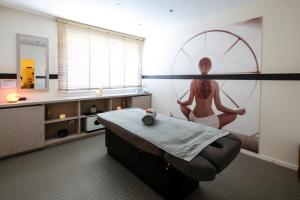 a room with a woman sitting on a ottoman at Thalazur Ouistreham - Hôtel & Spa in Ouistreham