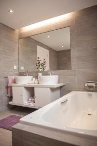 Un baño con dos lavabos y un espejo grande. en Casa do Ácer, en São Vicente Ferreira