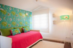 Un dormitorio con una cama rosa con cabecero verde. en Casa do Ácer, en São Vicente Ferreira