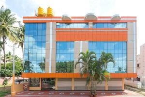 um edifício com janelas laranja e azul e palmeiras em Sree Comforts em Kushalanagar