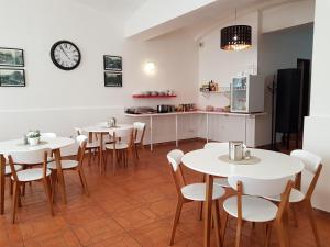 a room with tables and chairs and a clock on the wall at Hotel Richmond Teplice in Teplice