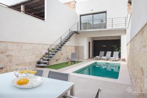 a house with a swimming pool and a table with wine glasses at Ca Na Foc in Sa Pobla
