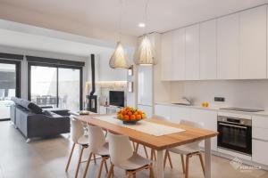 a kitchen with a wooden table and white cabinets at Ca Na Foc in Sa Pobla