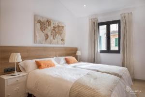 a bedroom with a bed with white sheets and orange pillows at Ca Na Foc in Sa Pobla