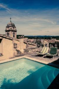 a swimming pool on top of a building at Hotel de L Orange in Sommières