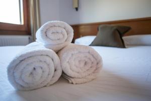 una pila de toallas sentadas encima de una cama en Fonda Barris, en Joanetes