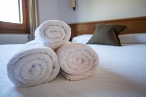 a pile of towels sitting on top of a bed at Fonda Barris in Joanetes